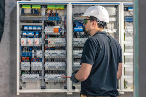 male-electrician-works-switchboard-using-electrical-connection-cable