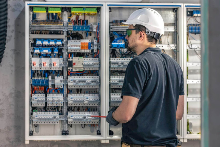 male-electrician-works-switchboard-using-electrical-connection-cable